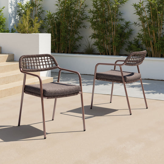 Two outdoor chairs on a patio with plants in the background