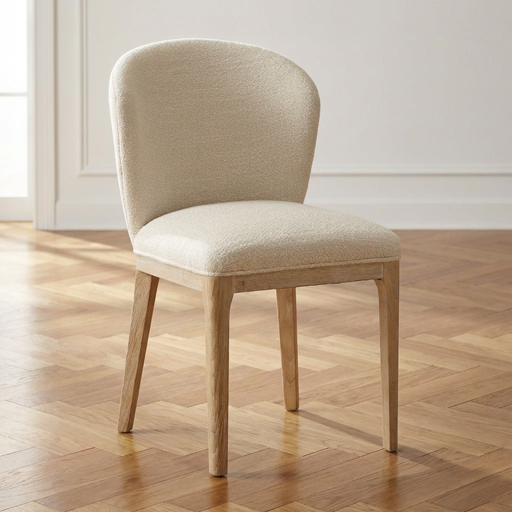 Beige upholstered chair on a wooden floor with a neutral wall background