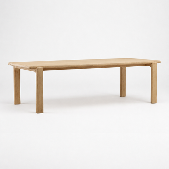 Rectangular wooden table with a light natural oak finish, shown against a seamless white studio background.