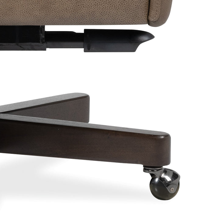 Close-up detail of an office chair showing the dark brown wooden base, a black castor wheel, and part of a taupe textured upholstered seat on a white background.