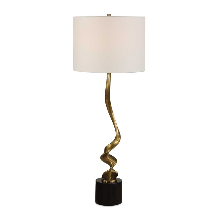 Decorative table lamp with a gold spiral base and white shade on a white background