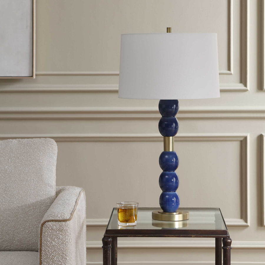 Blue lamp with white shade on a neutral background