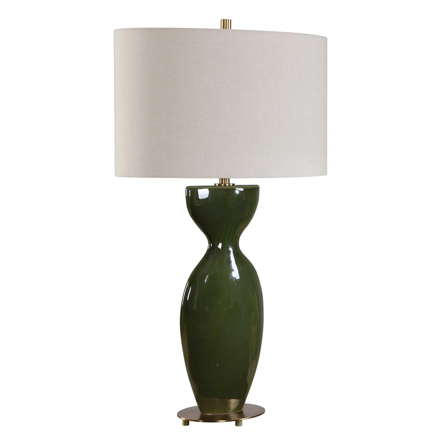 olive-green ceramic lamp base topped by a oval linen shade, brass accents at neck and base