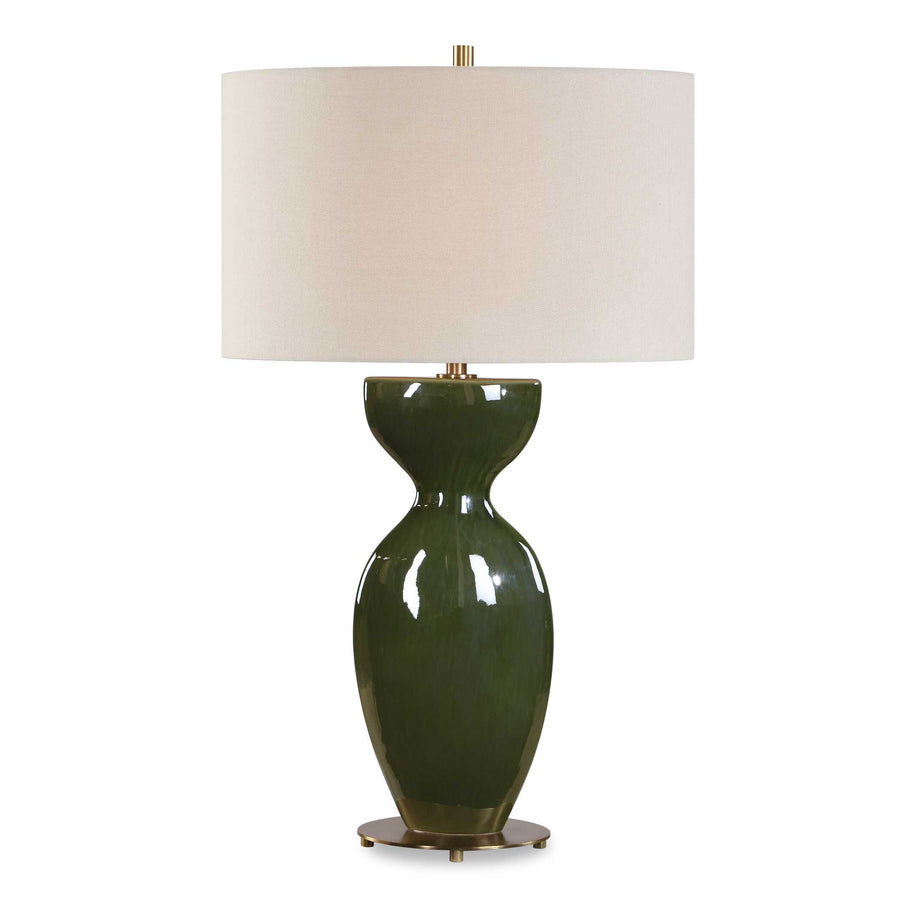 olive-green ceramic lamp topped by a oval linen shade, brass accents at neck and base