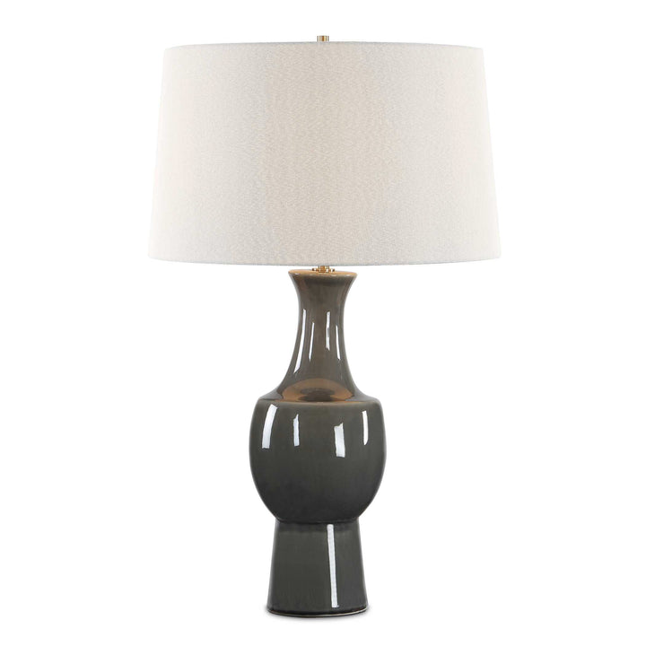 A table lamp with a glossy dark gray ceramic base and a textured off-white fabric drum shade
