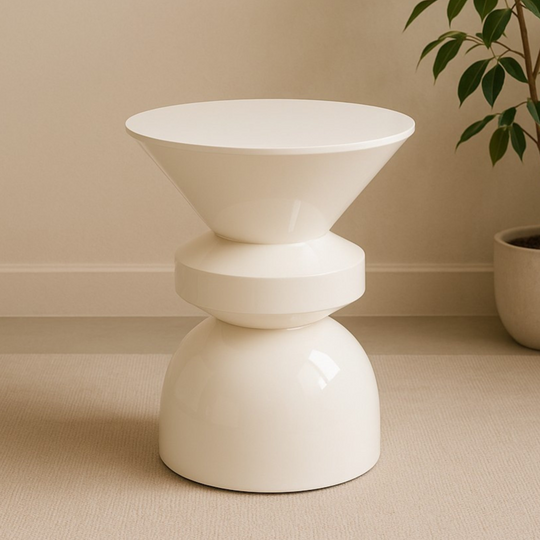 White modern side table on a beige floor with a plant in the background
