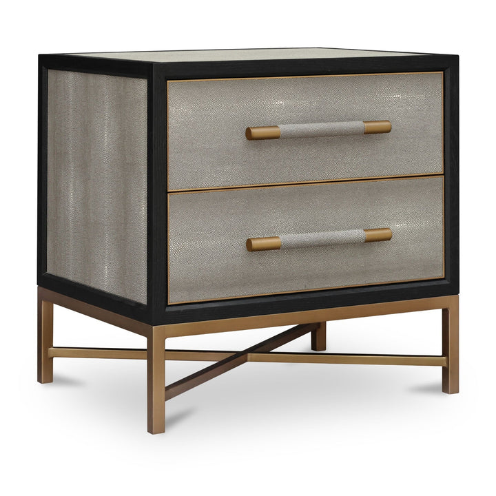 Modern two-drawer nightstand, black wooden frame, textured beige shagreen-like drawer fronts, brass cylindrical handles, brass X-shaped base