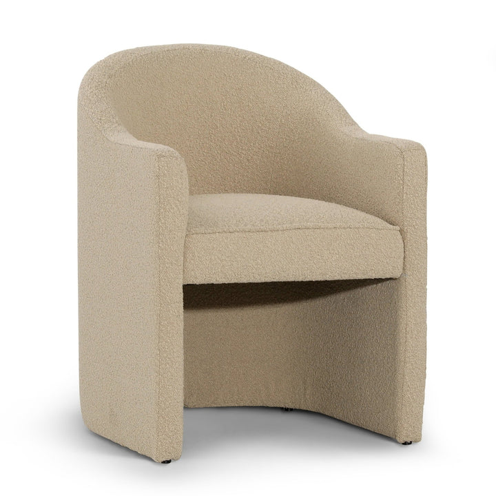 A beige upholstered Melba dining chair with a curved back and slender arms, made of solid pine wood.
