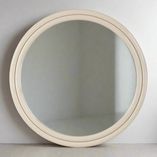 Round mirror with a beige frame on a white background