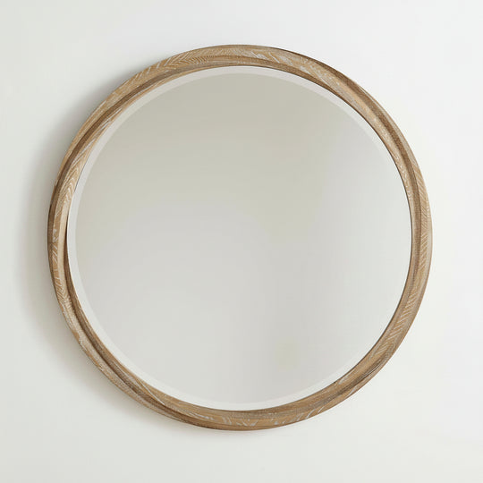 Round wooden-framed mirror isolated on a wall