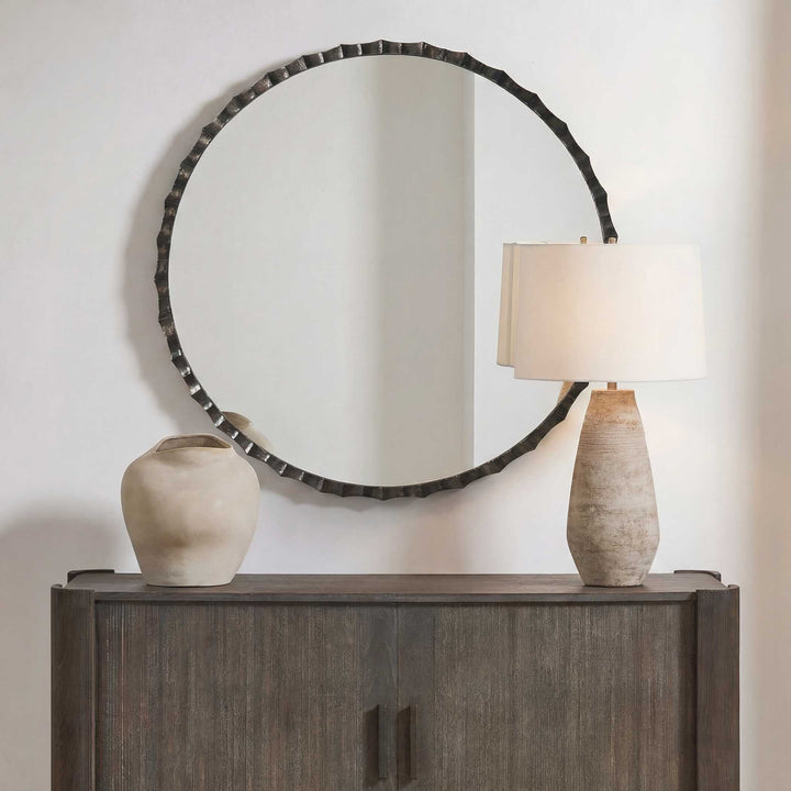 Round mirror with decorative frame on a wall
