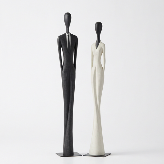 Black and white tall mannequin sculptures on a light gray background