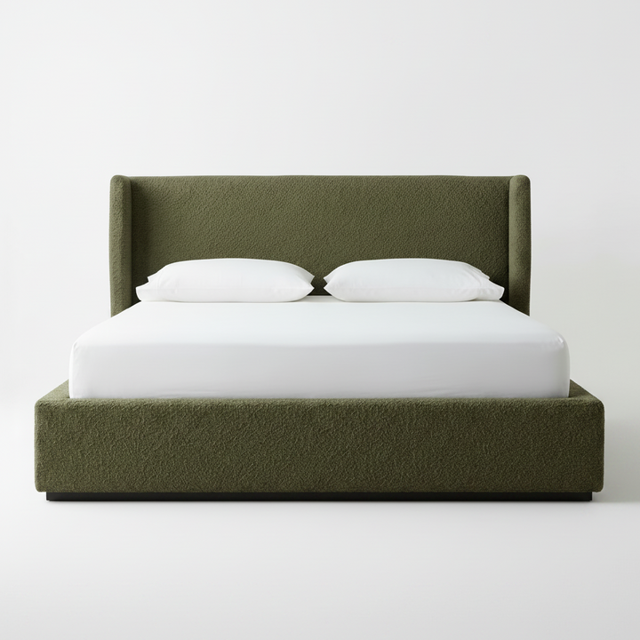 Green upholstered bed with white bedding on a plain background