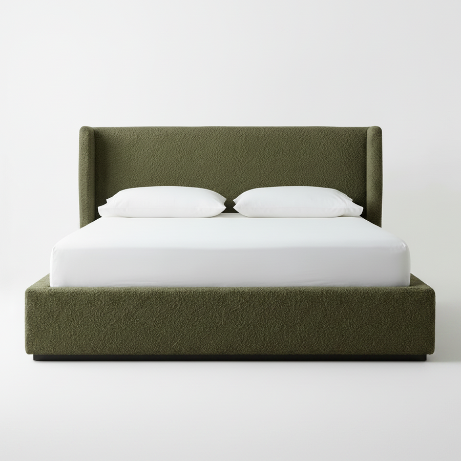 Green upholstered bed with white bedding on a plain background