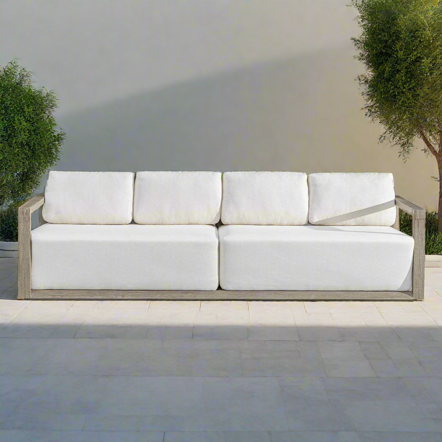 White outdoor sofa with wooden frame on a patio