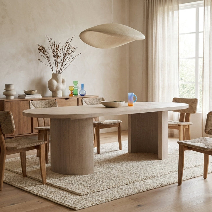 A modern oval dining table with a light gray wood grain finish, shown against a plain white background.