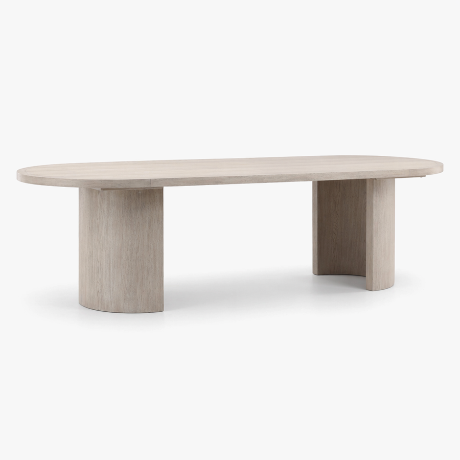 An oval dining table with a light beige wood grain finish and thick cylindrical pedestal legs, shown against a plain white background.