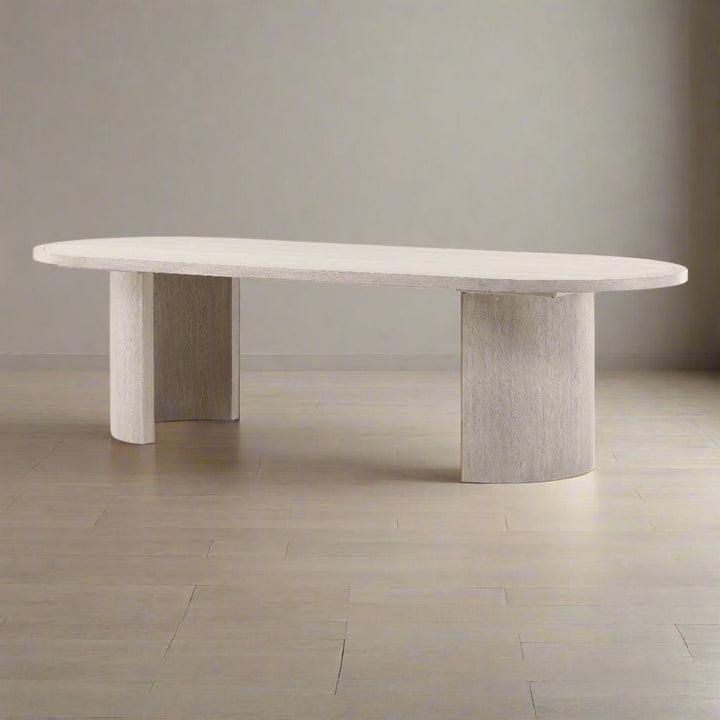 Modern dining table with a light wood finish on a neutral background