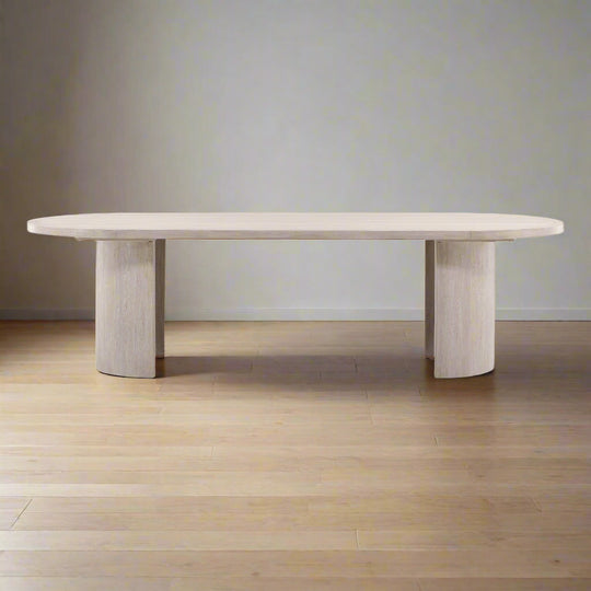 Modern dining table with a light wood finish on a neutral background