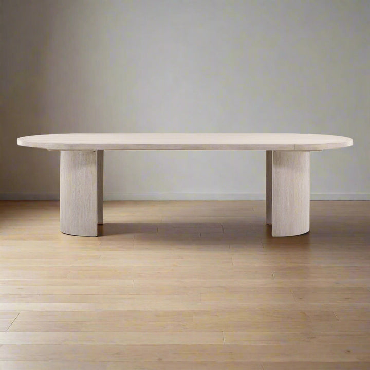 Modern dining table with a light wood finish on a neutral background