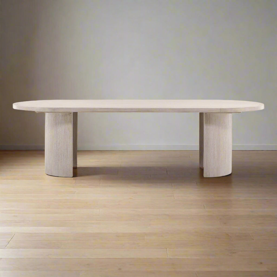 Modern dining table with a light wood finish on a neutral background