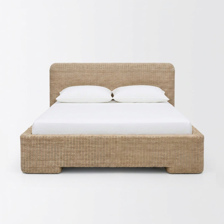 A low-profile platform bed with a woven natural fiber headboard and matching footboard, styled with a white mattress and two white pillows against a plain white background.