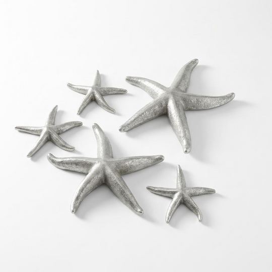 Set of silver starfish decorations on a white background