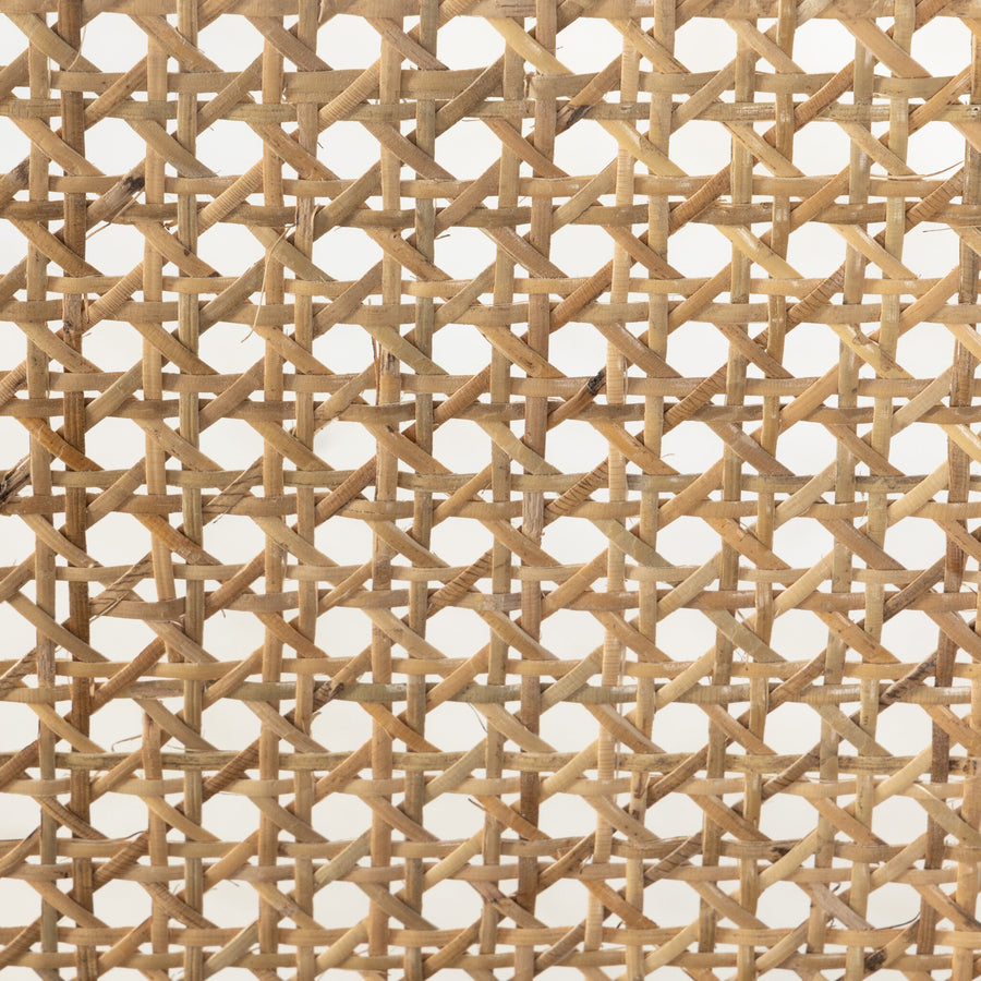 Close-up of a woven cane backrest pattern of a wooden bench showcasing intricate crisscrossed fibers.