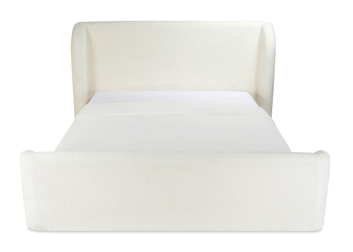 cream upholstered bed with curved headboard and footboard