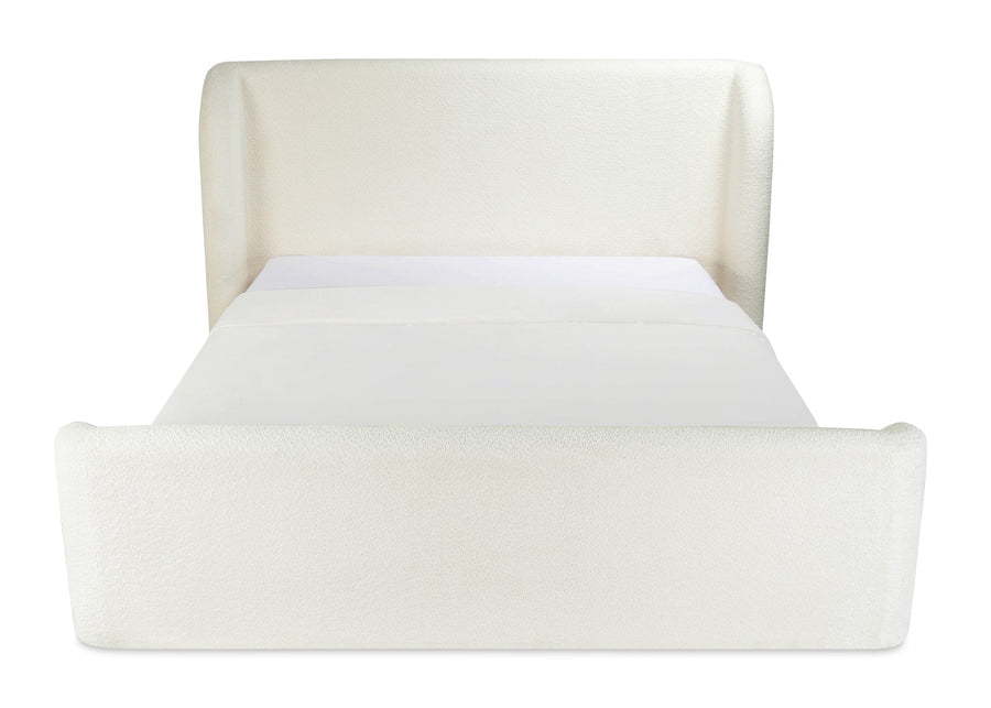 cream upholstered bed with curved headboard and footboard