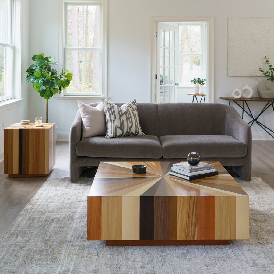 Cozy living room featuring a gray sofa, striped pillows, and a vibrant wood-patterned sun coffee table.