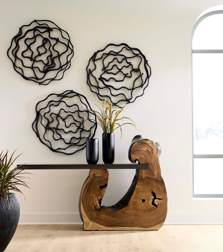 Decorative wall art with floral designs above a wooden console table.