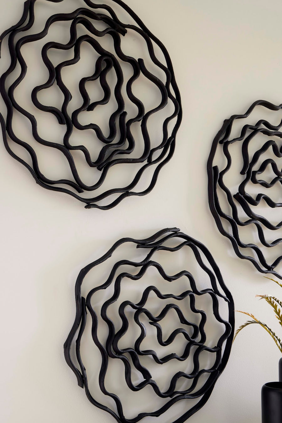 Three black wire wall art pieces on a white background