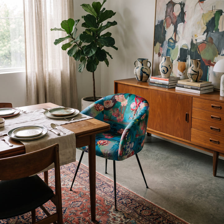 Tropical print velvet dining chair with a vibrant floral pattern, styled in a modern, eclectic dining room setting.