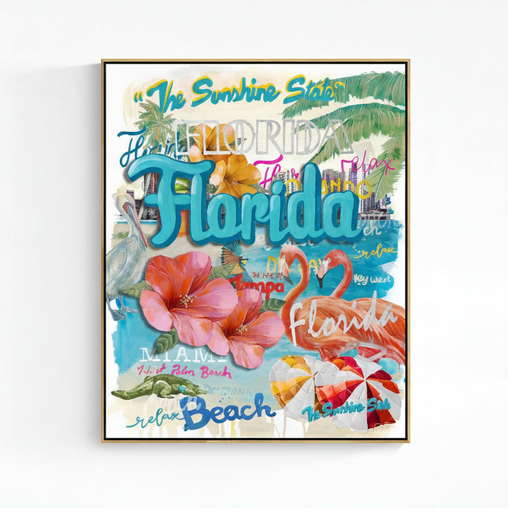 A gold framed Florida-themed art print featuring colorful typography, palm leaves, hibiscus flowers, flamingos, beach umbrellas, and tropical scenery on a white wall.