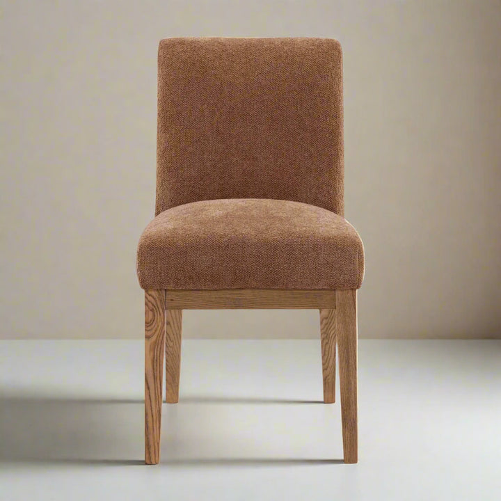 Brown upholstered chair with wooden legs on a white background