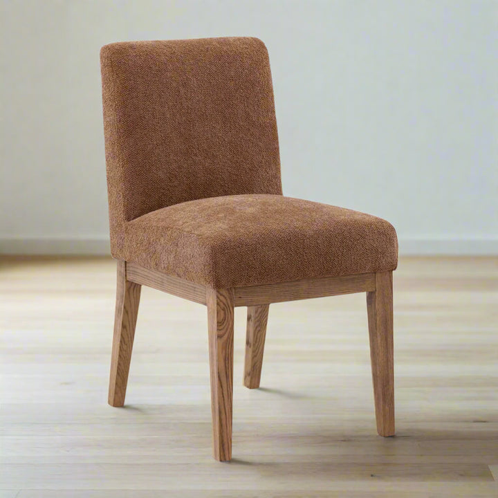 Brown upholstered chair with wooden legs on a white background
