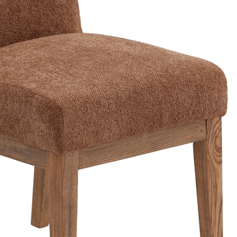 Brown upholstered chair with wooden legs on a white background