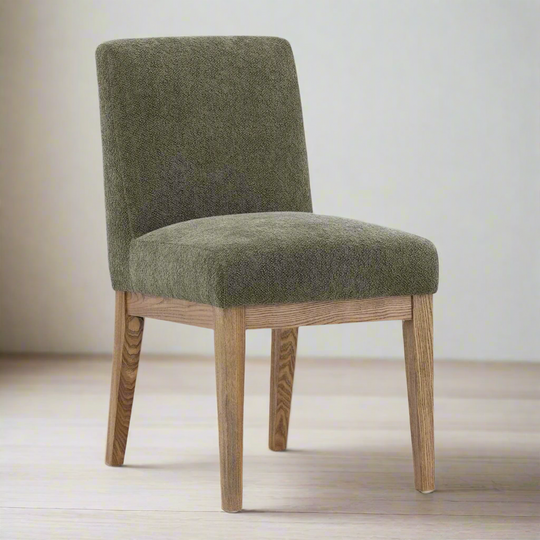 Green upholstered chair with wooden legs on a light wood floor.