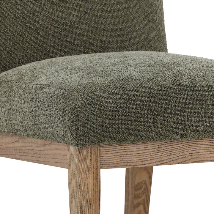 Green upholstered chair with wooden legs on a white background