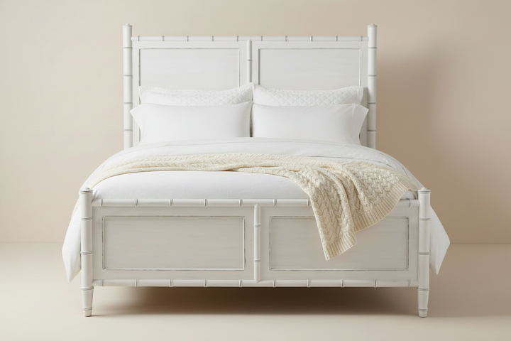White bed with bamboo-style headboard and bedding on a beige background