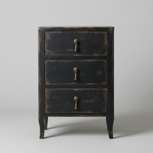 A three-drawer nightstand with a distressed black finish and antique brass drawer pulls, photographed against a neutral light gray background.