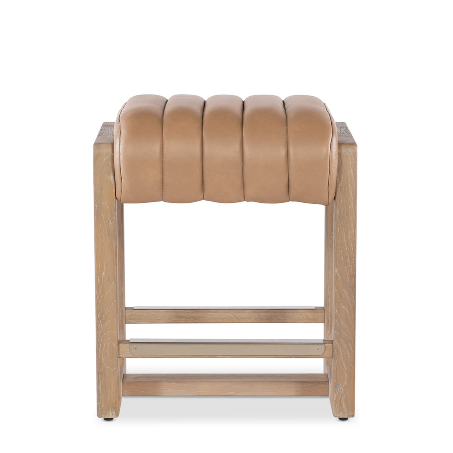 A tan leather banyan counter stool wooden legs against a white background.