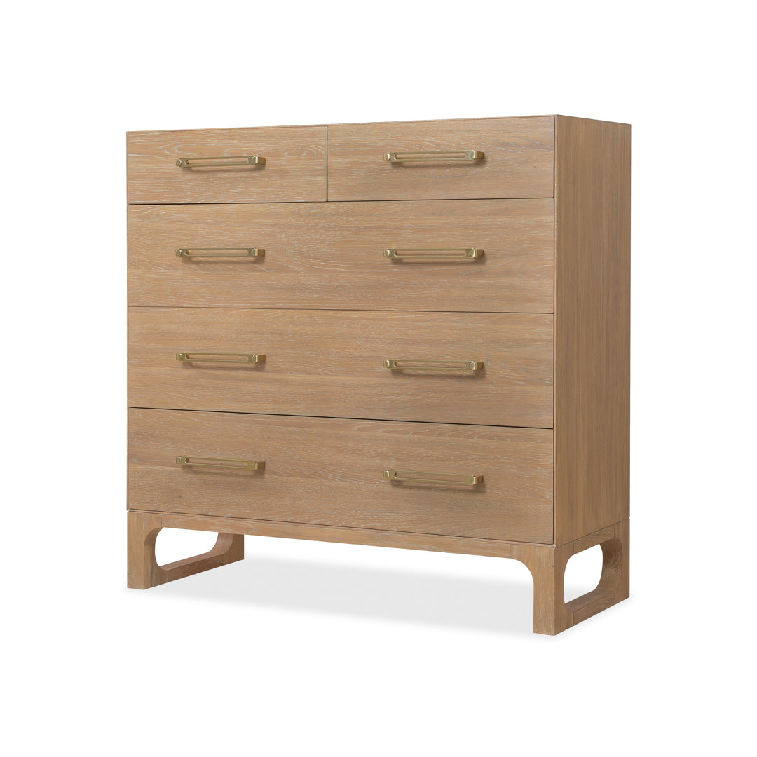 Angled view of a wooden dresser with a light oak finish, five drawers, and brass handles.