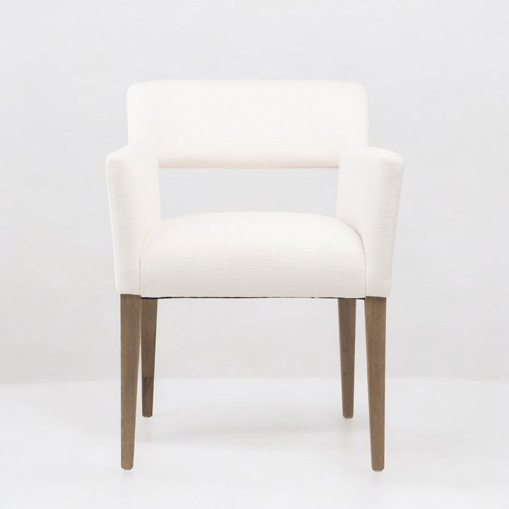 White linen armchair with wooden legs on a white background