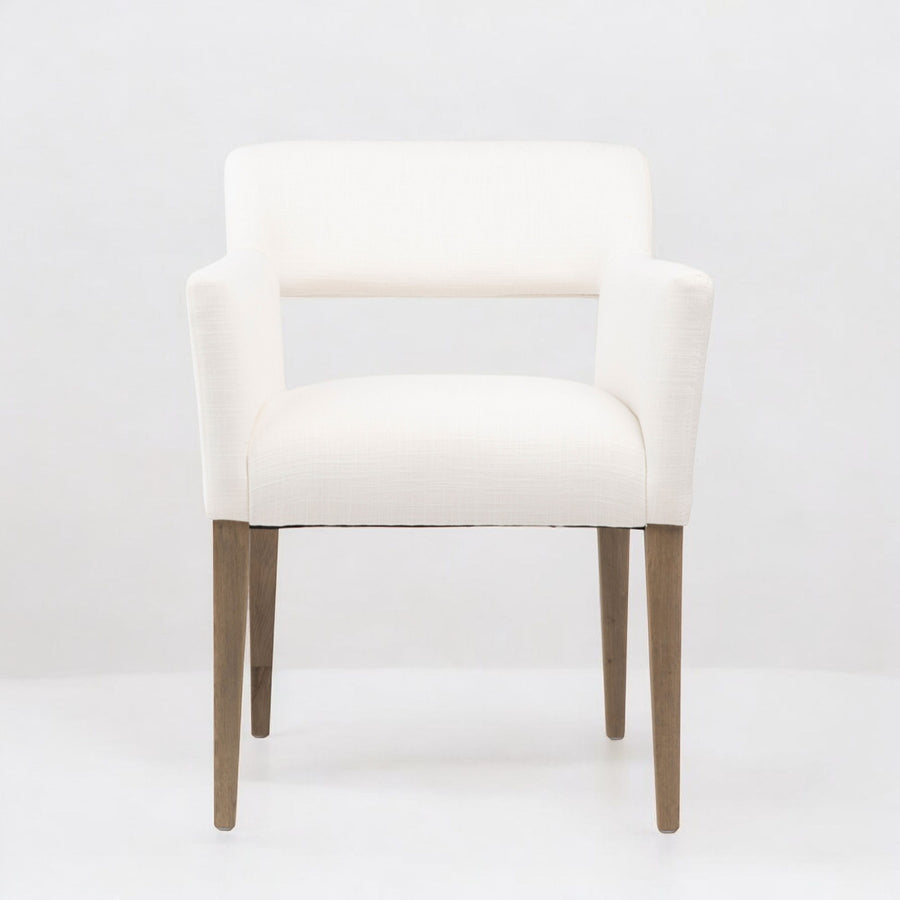 White linen armchair with wooden legs on a white background
