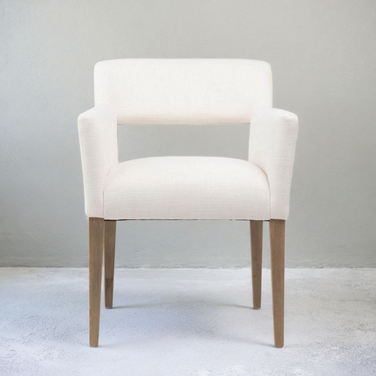 White armchair with wooden legs on a light gray background