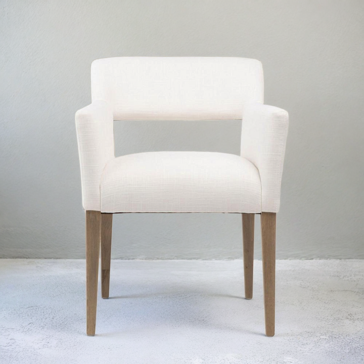 White armchair with wooden legs on a light gray background