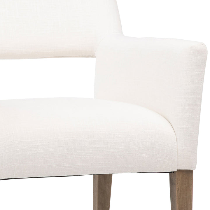 Close-up of a white upholstered chair with wooden legs on a white background