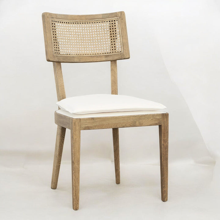 Angled view of a wooden dining chair with a light cushion.